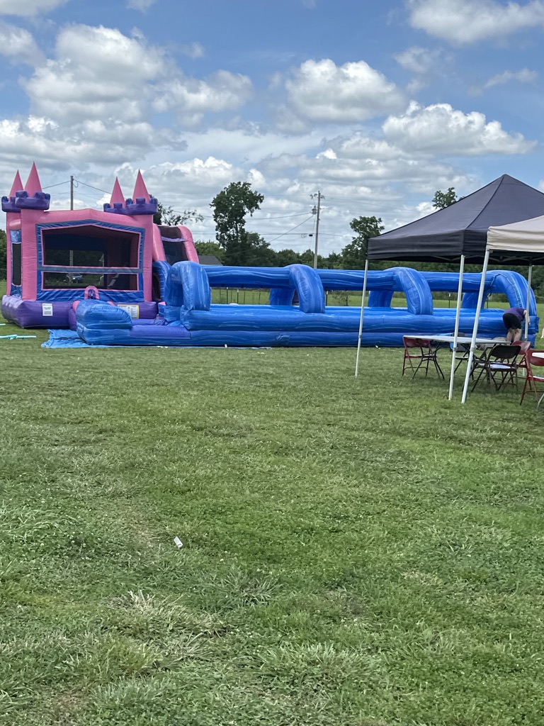The full bounce house and slip-slide setup with tent