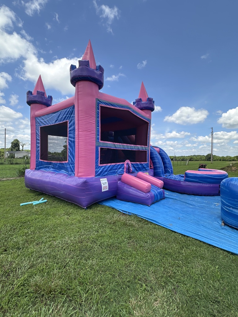 Castle bounce house with water slide on the grass